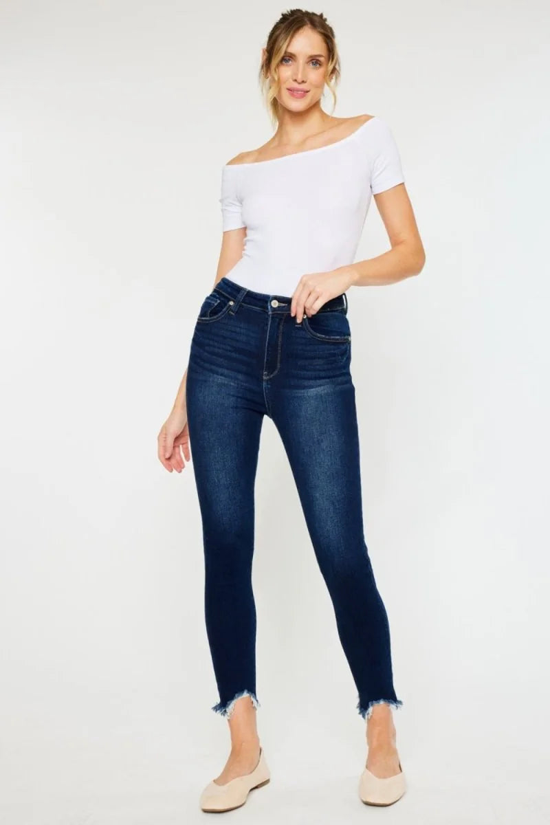 Dark wash skinny jeans with a frayed hem, on a model.