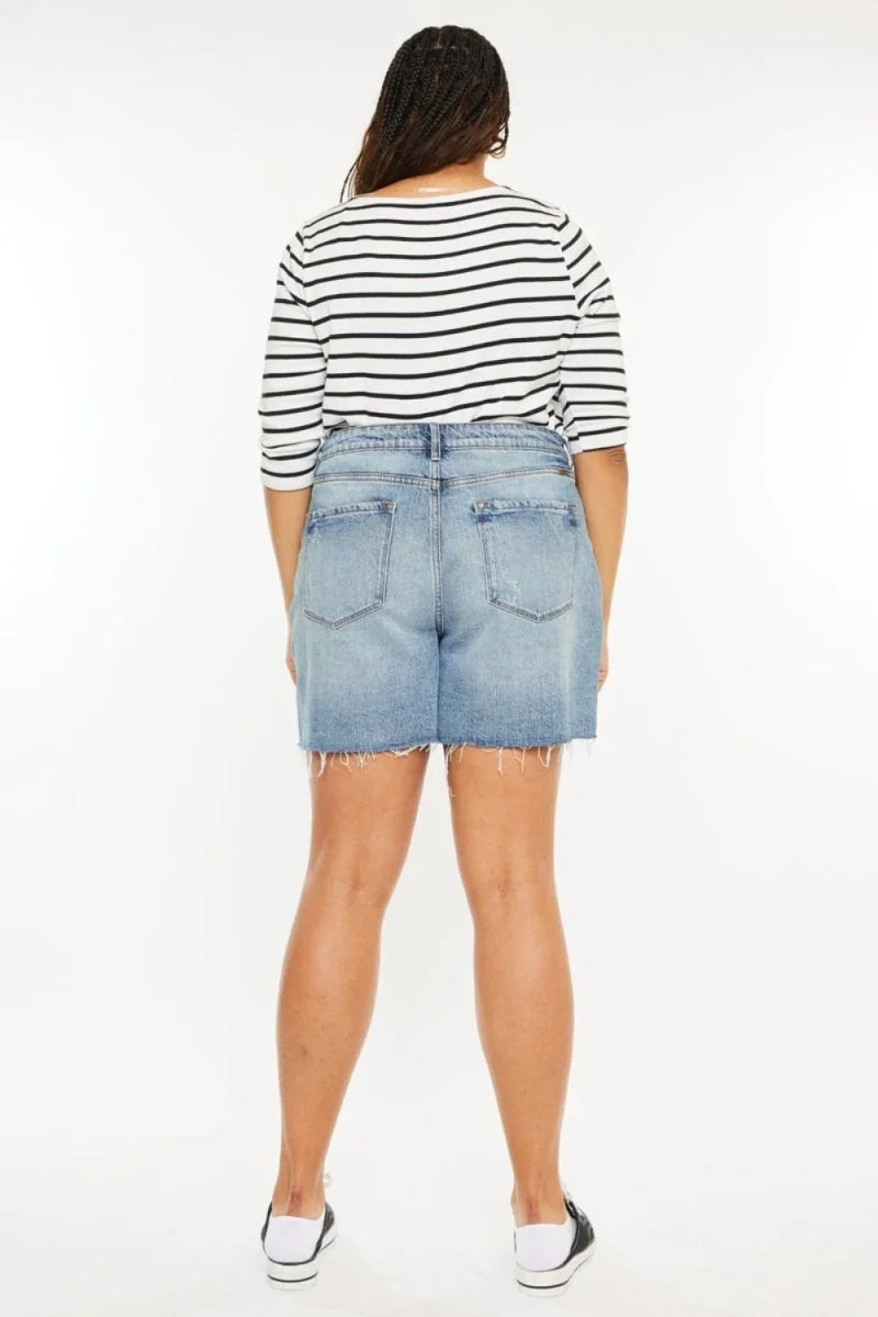 Light wash denim shorts with frayed hem and distressed details, shown from the back on a model.