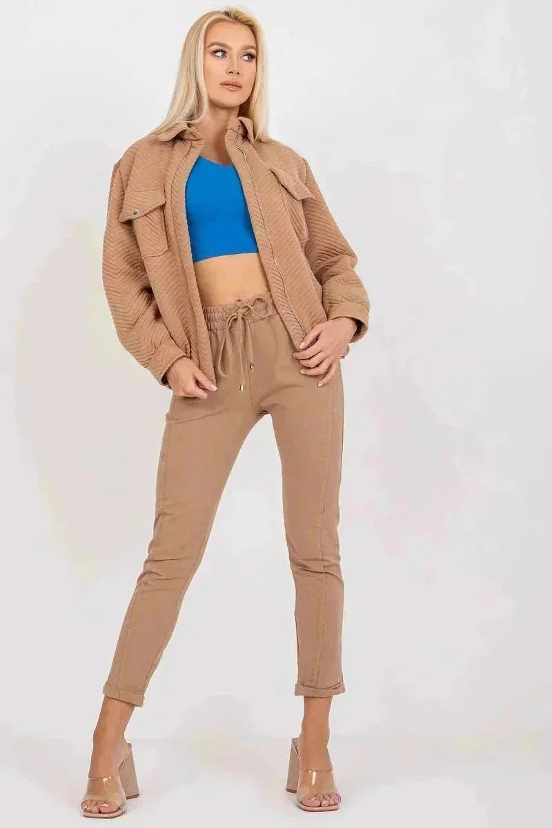 Tan quilted jacket with snap pockets and drawstring pants on model.