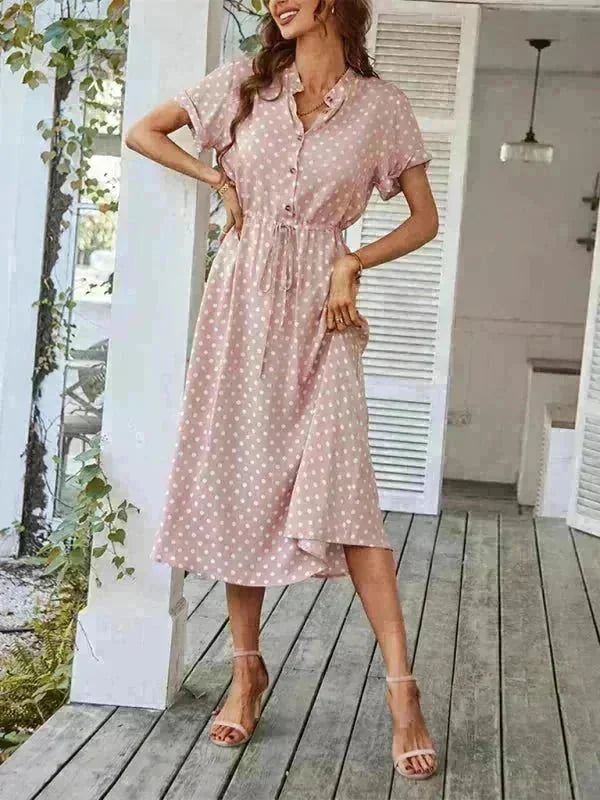 Pink polka dot rayon dress with tie waist and ankle strap sandals on model
