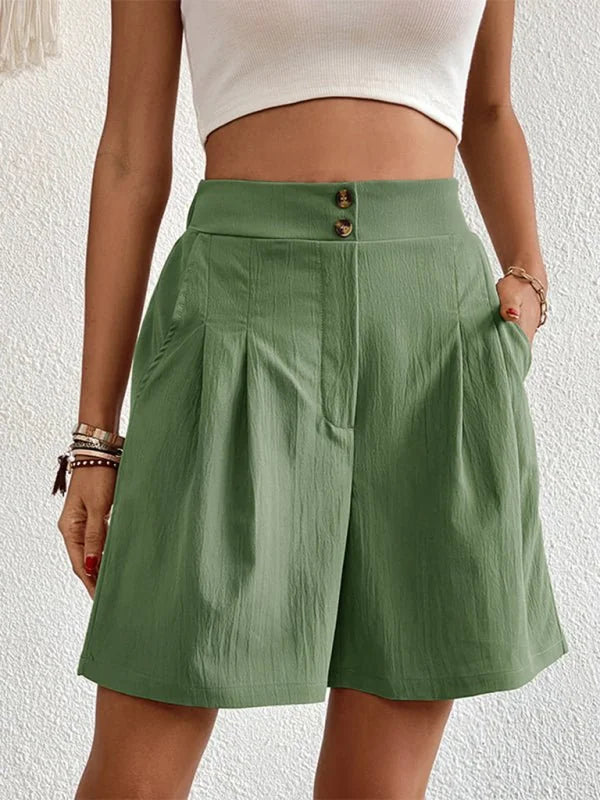 Green linen-blend shorts with a pleated front and button closure, shown on a model.