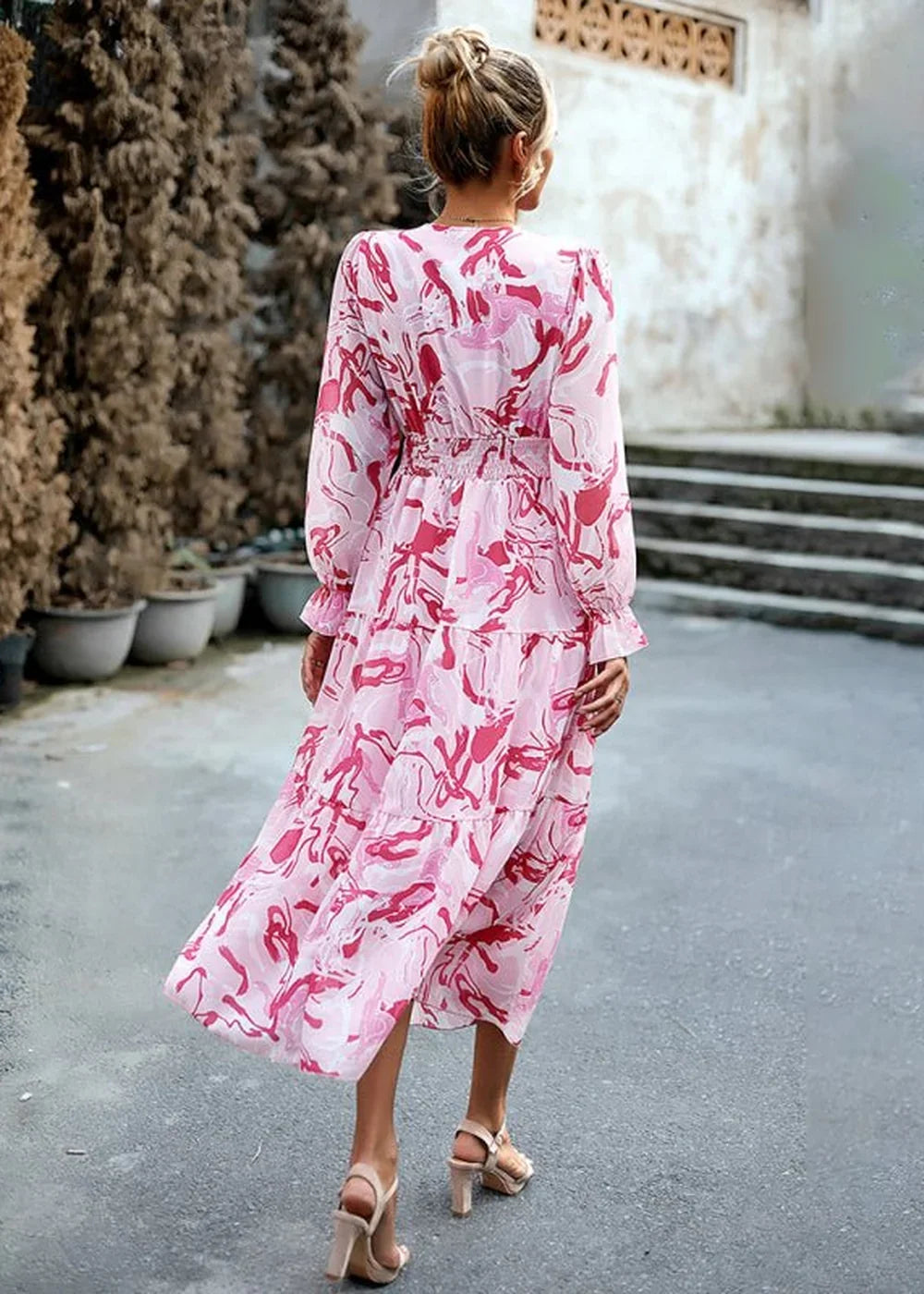 Pink and red abstract print tiered midi dress with long sleeves and square neck, on model.