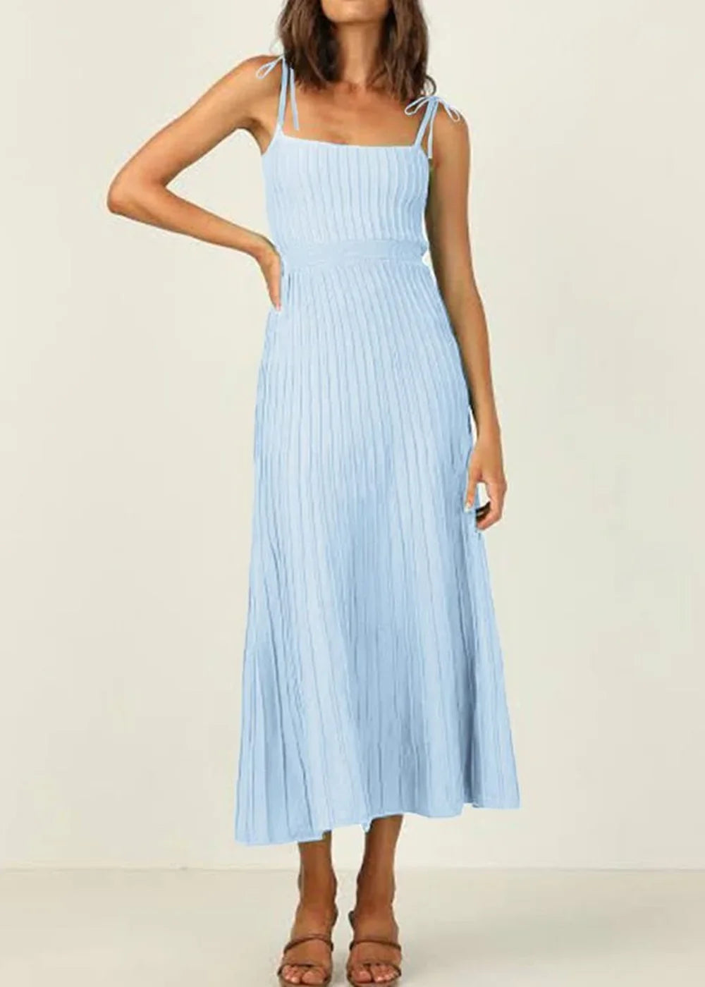 Light blue ribbed knit midi dress with tie straps and a pleated skirt, on model.