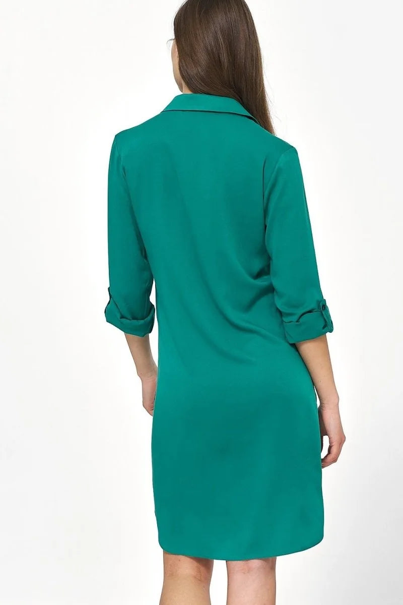 Back view of an oversized, emerald green viscose day dress with cuffed sleeves.