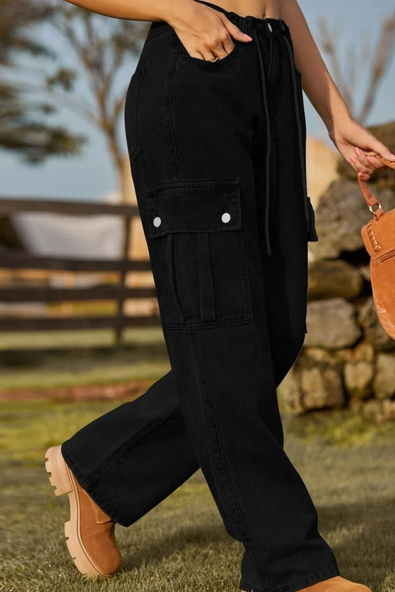 Woman in black cargo pants and tan boots walking outdoors.