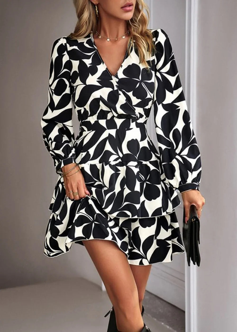 Black and white abstract floral print dress with a V-neck, long sleeves, and tiered ruffled skirt on a model.