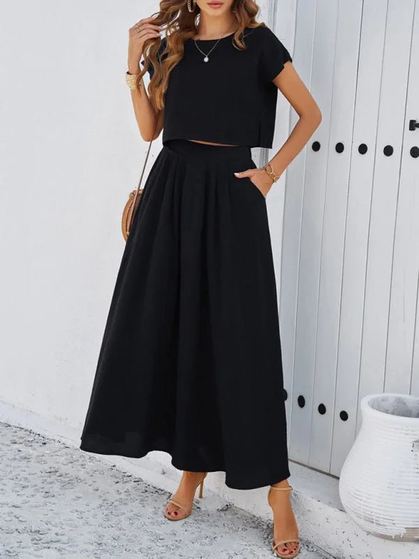 Black crop top and midi skirt set with pockets and a straw crossbody bag.