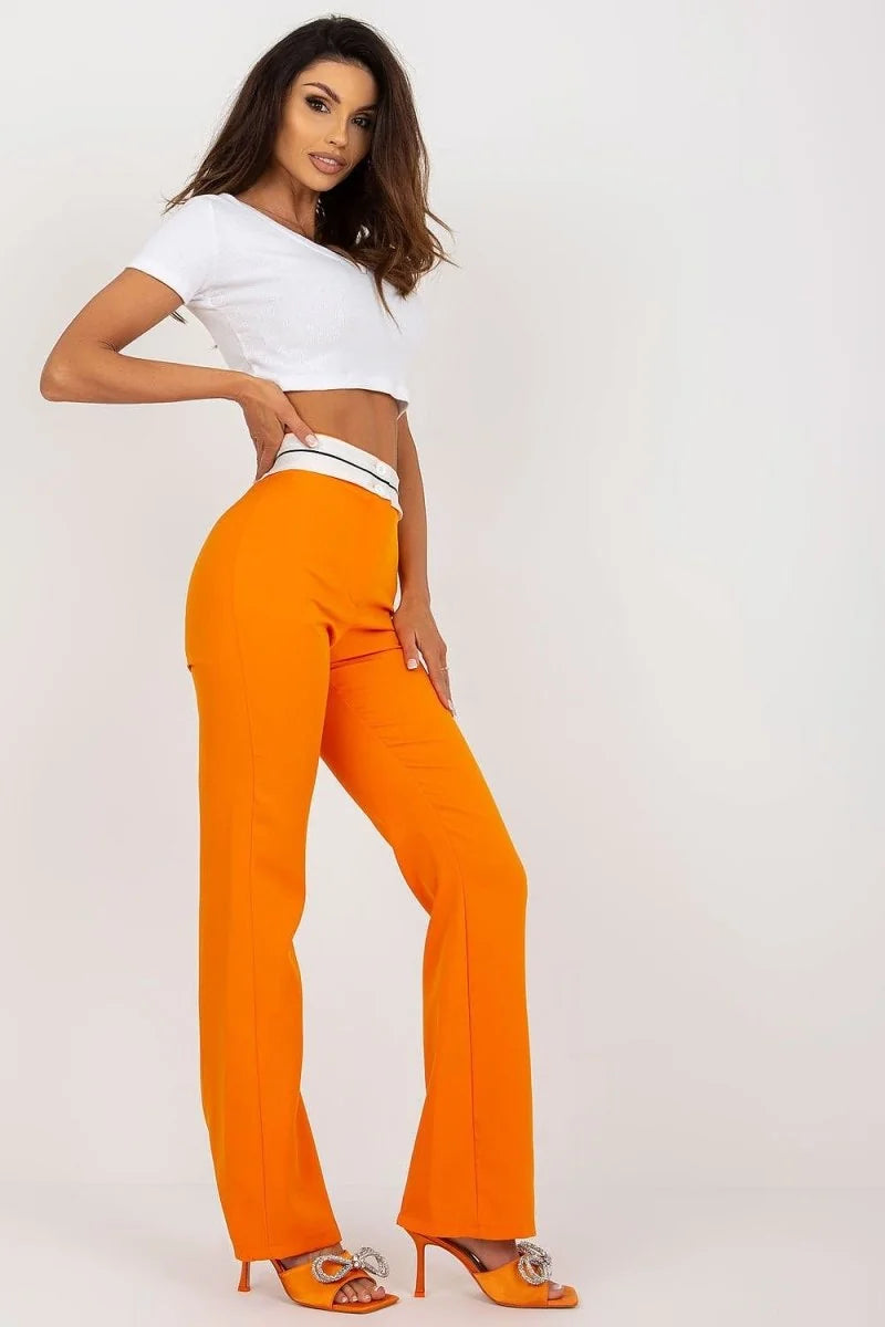 Bright orange wide-leg pants with a white and black striped waistband, shown on a model.