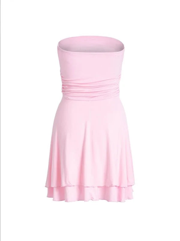 Light pink strapless dress with ruched bodice and tiered hem.