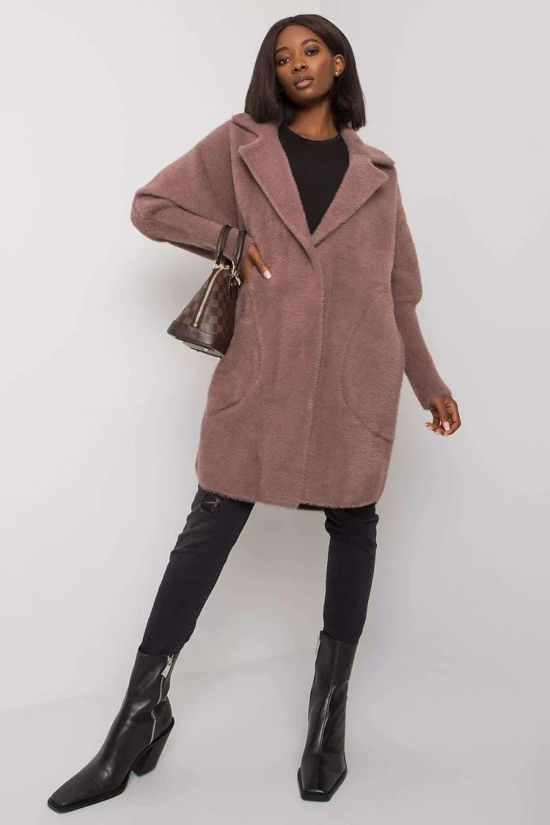 A woman wears a plush, taupe angora wool blend coat with a relaxed fit, black jeans, and black pointed-toe boots.