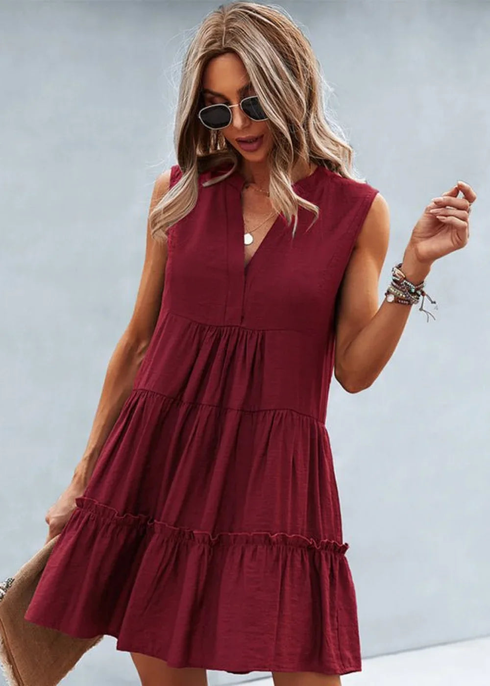 Maroon tiered ruffle dress with a V-neck and sunglasses on a model.