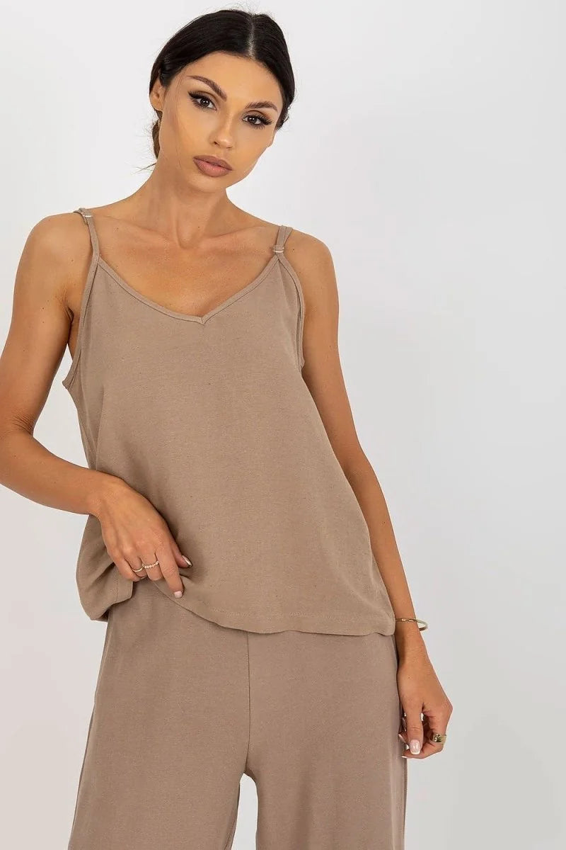 Loose-fitting, taupe camisole top with adjustable spaghetti straps and v-neck, shown on model.