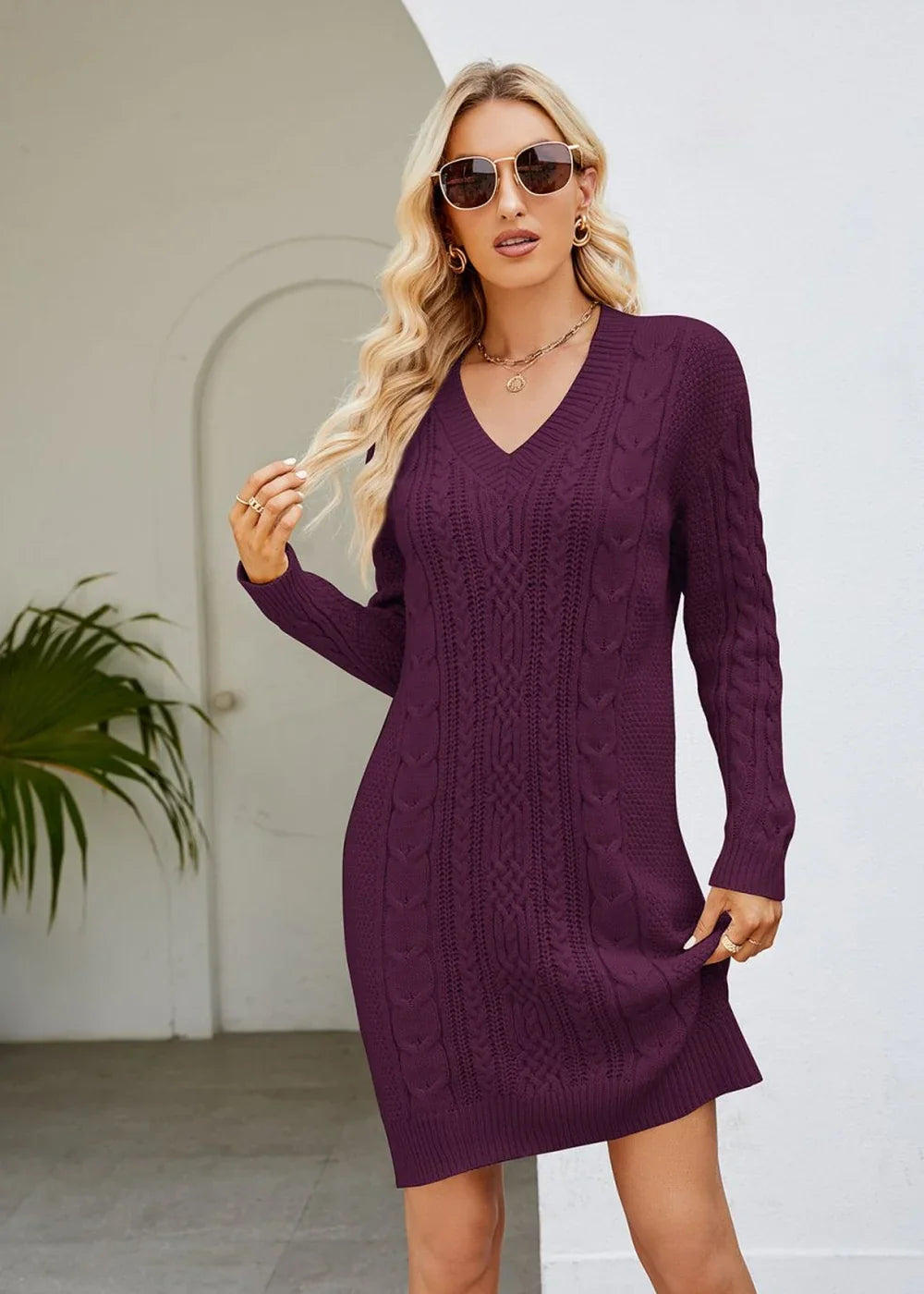 Wine cable knit V-neck sweater dress with long sleeves on a model.