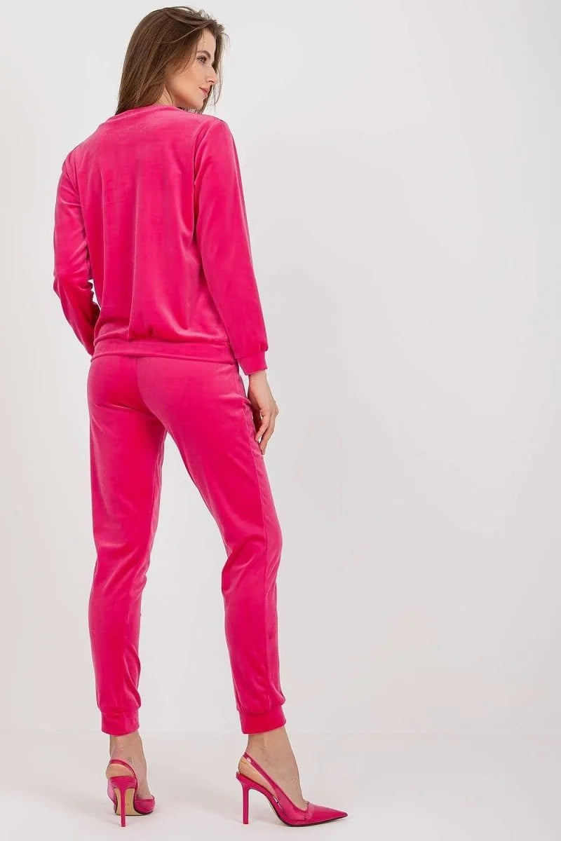 Woman in hot pink velour tracksuit and slingback heels, back view.