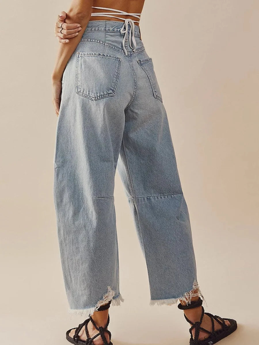 Light wash, high-waisted, wide-leg jeans with frayed hems and distressed detailing.