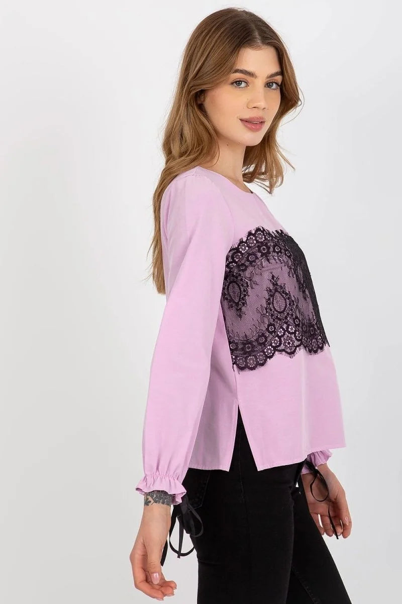 Light pink long-sleeve top with black lace detail on the chest and tie accents on the cuffs.