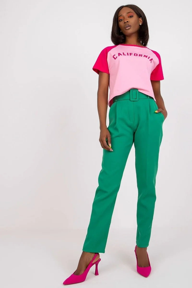 Green high-waisted pants with a matching belt on a model.