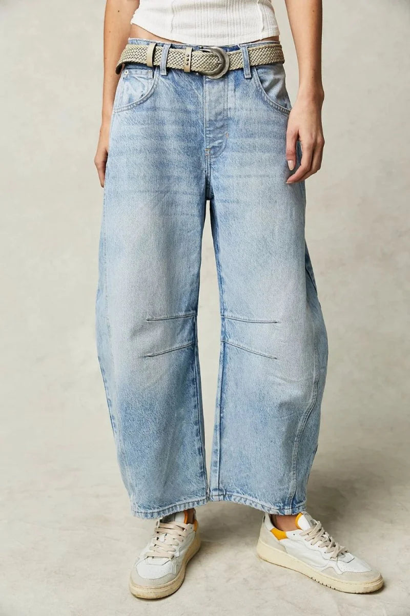 Light blue relaxed fit denim jeans with a braided belt and white sneakers.