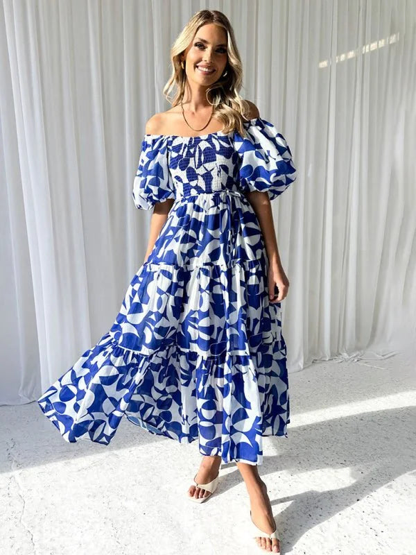 Off-the-shoulder blue and white abstract print maxi dress with tiered skirt and puff sleeves, on model.
