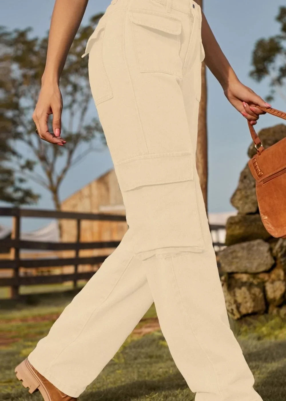 Cream cargo pants with large pockets, on a model walking outdoors.