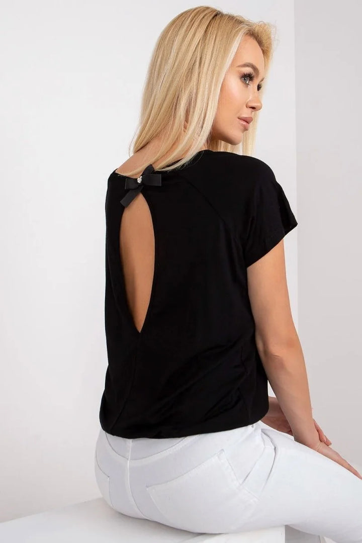 Black t-shirt with a cutout back and a bow detail at the neckline, shown on a model wearing white jeans.