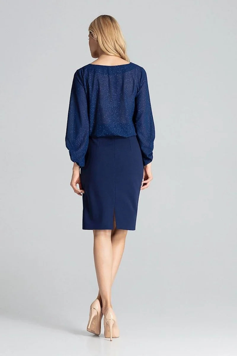 Navy blue pencil skirt with a back slit, worn by a woman in a sparkly blue blouse and nude heels.