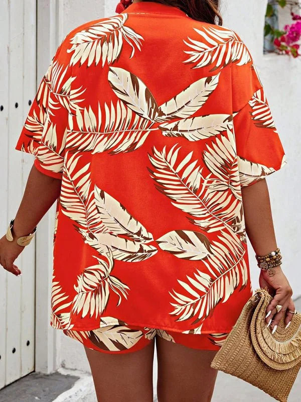 Orange tropical leaf print short suit with a woven clutch and stacked bracelets.