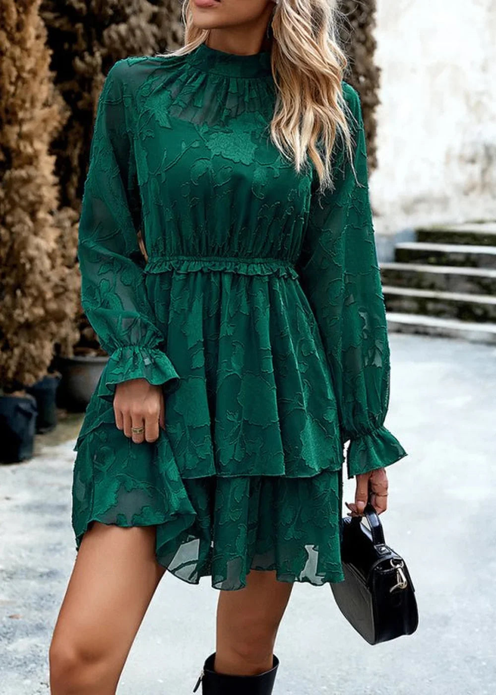 Emerald green tiered dress with textured floral pattern and ruffled cuffs.