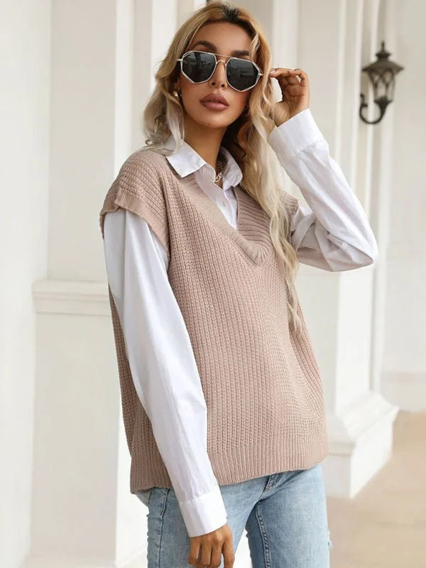 Beige knit vest over a white collared shirt on a woman wearing sunglasses and jeans.