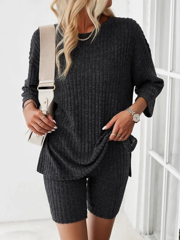 Dark grey ribbed knit loungewear set on model, featuring a long-sleeve top and bike shorts.