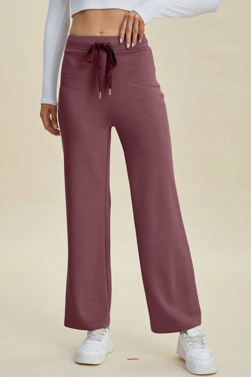Burgundy wide-leg pants with drawstring waist and white sneakers.