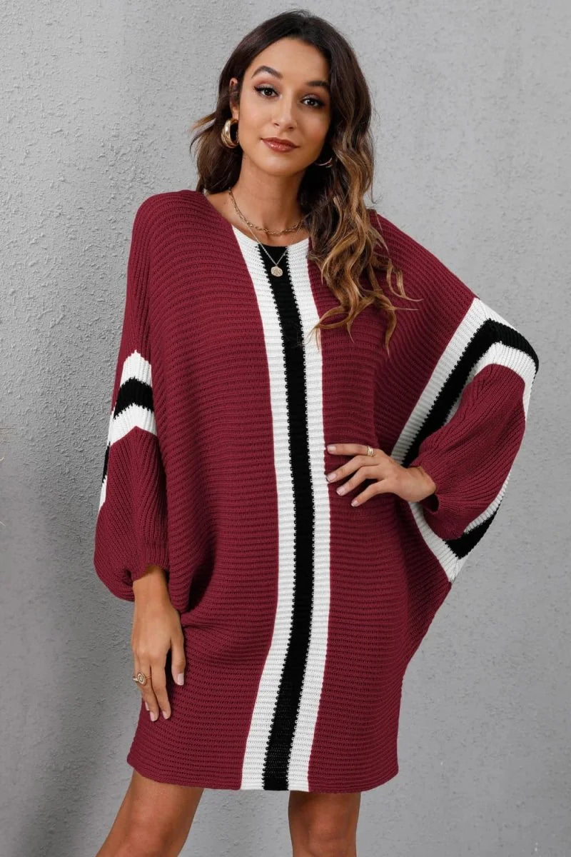 Burgundy sweater dress with bold black and white vertical stripes and dolman sleeves.