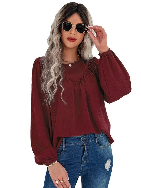 Maroon textured long-sleeve blouse with a cinched neckline, on a model wearing blue jeans.