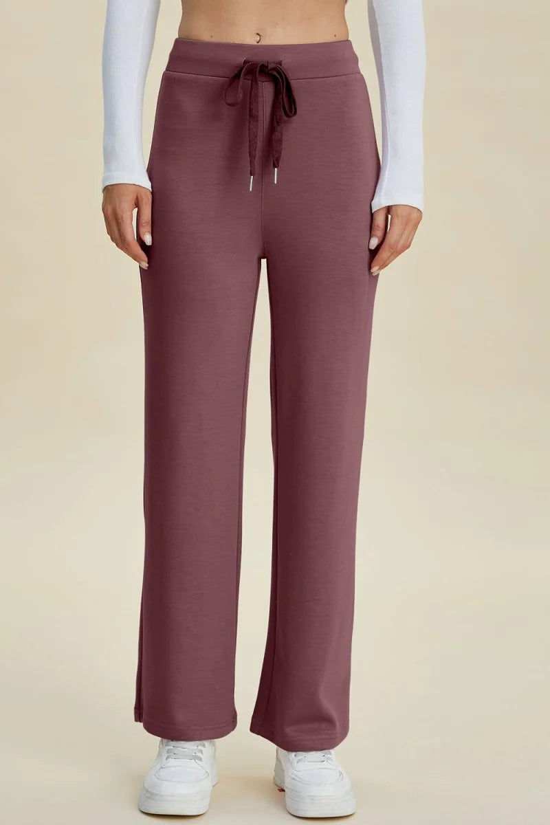 Plum ribbed wide-leg sweatpants with drawstring waist and white sneakers.