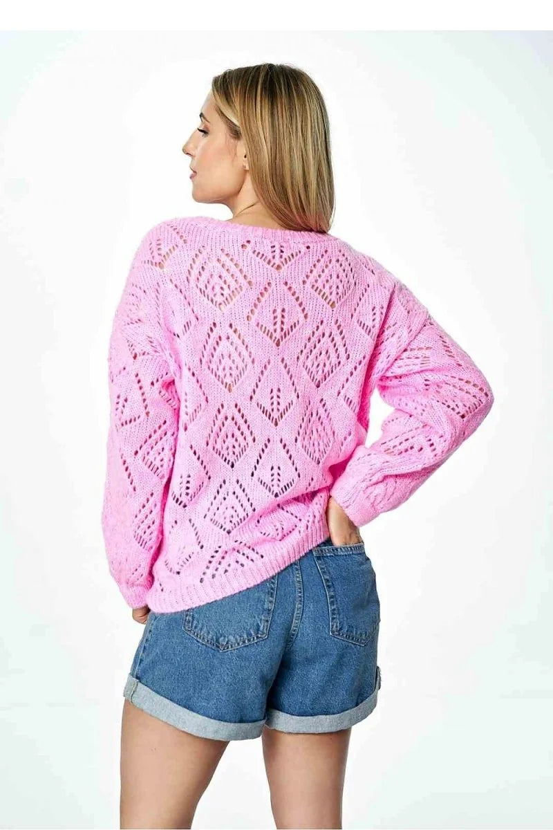 Pink chunky knit sweater with a diamond cutout pattern, worn by a model in denim shorts.