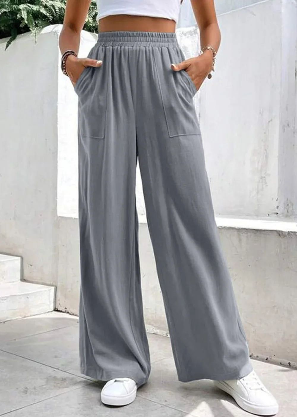 Gray wide-leg pants with pockets and elastic waistband, worn with white sneakers.