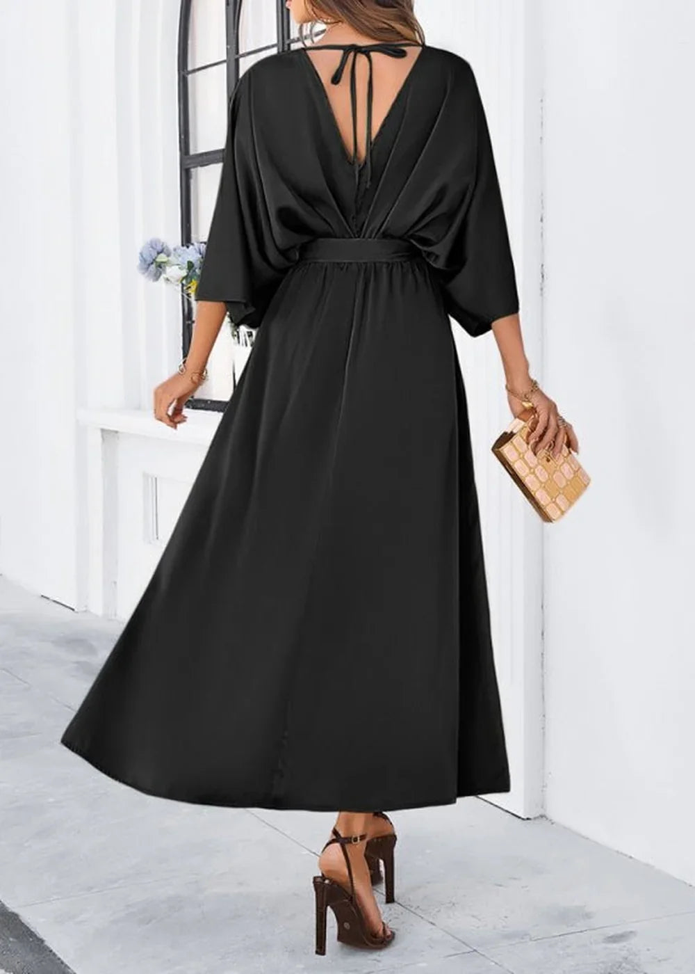 Black satin V-neck maxi dress with flutter sleeves and a tie-back detail.