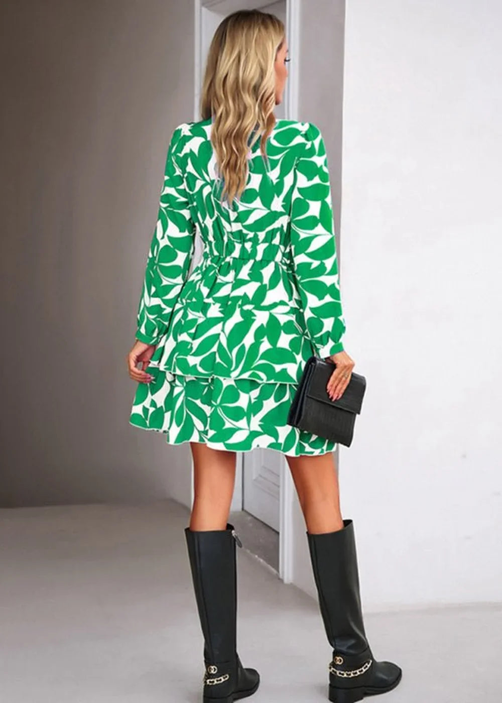 Green and white leaf print dress with tiered skirt, cinched waist, and black boots on model.
