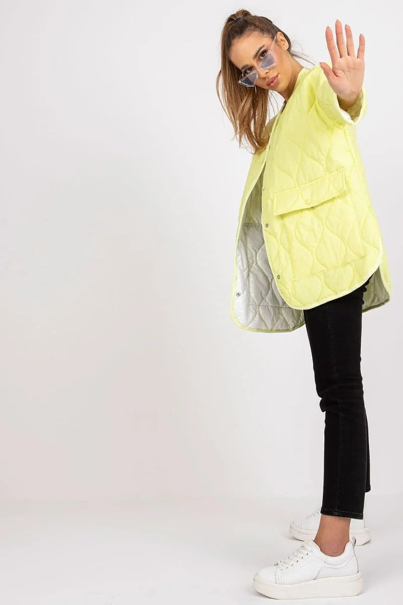 Lime green quilted jacket with white lining, worn by a model with black pants and white sneakers.