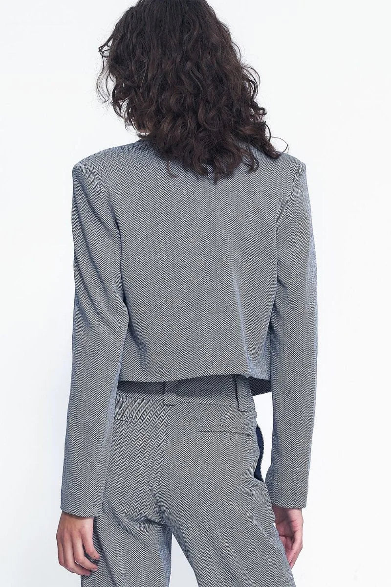 Back view of a cropped blazer with a black and white herringbone pattern.