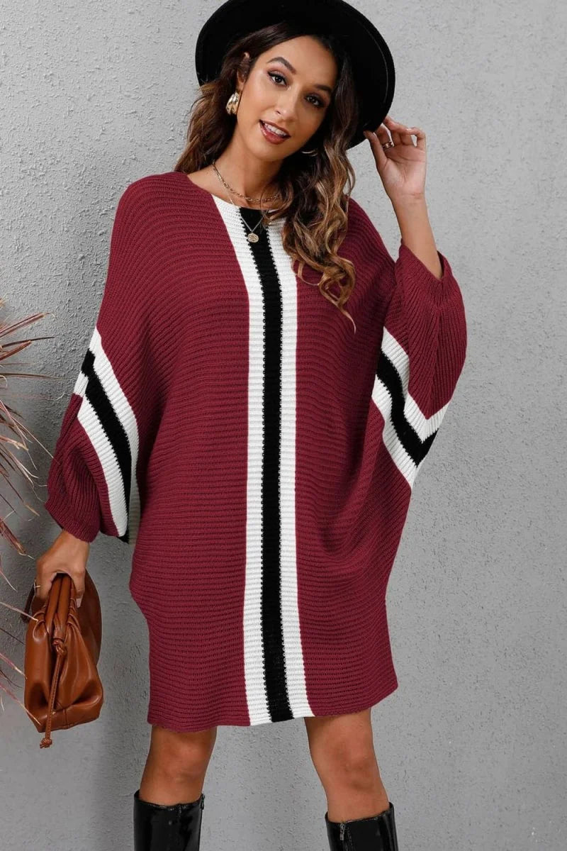 Burgundy knit sweater dress with white and black stripes, batwing sleeves, and a brown crossbody bag.