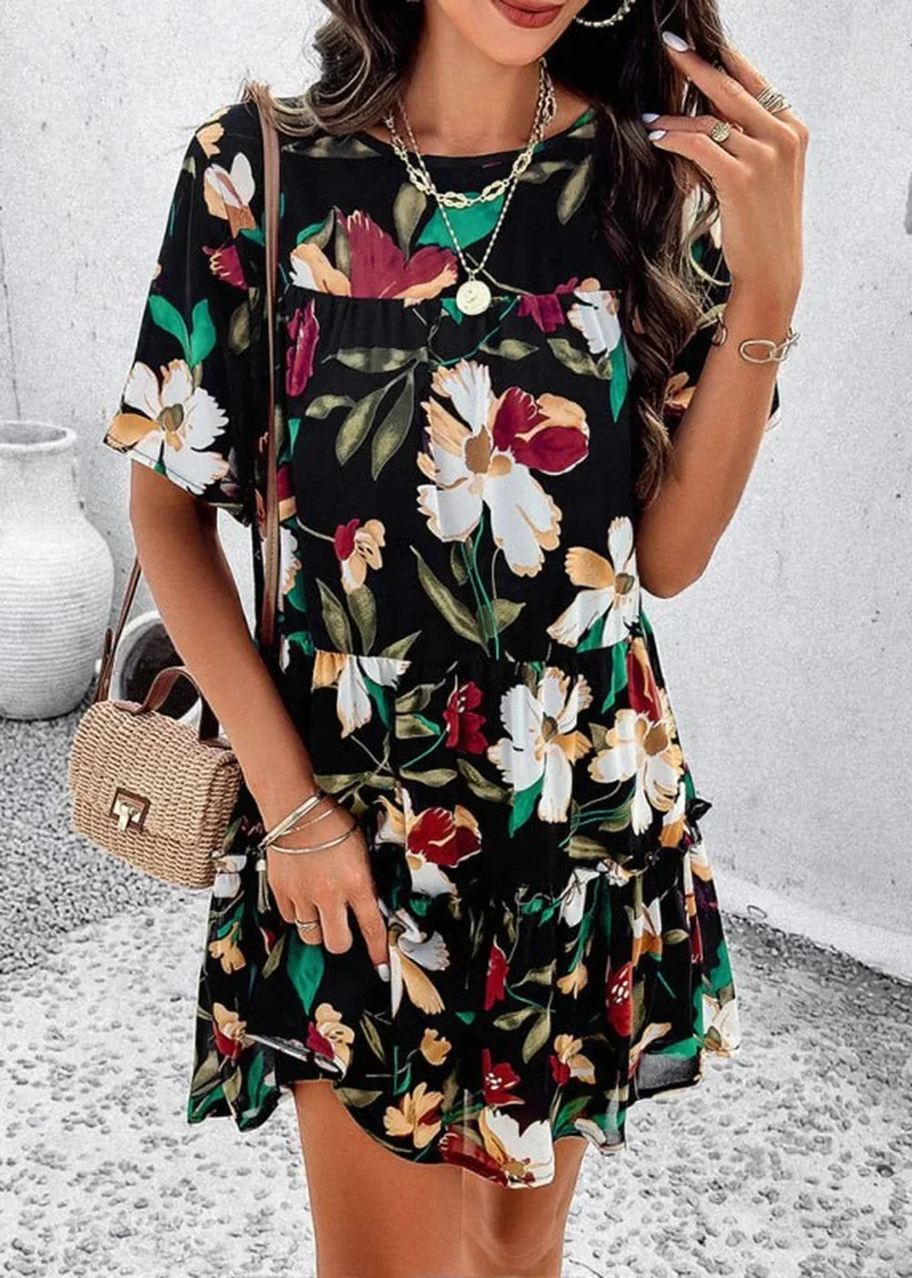 Black floral print polyester day dress with ruffled hem and short sleeves, worn by a model.