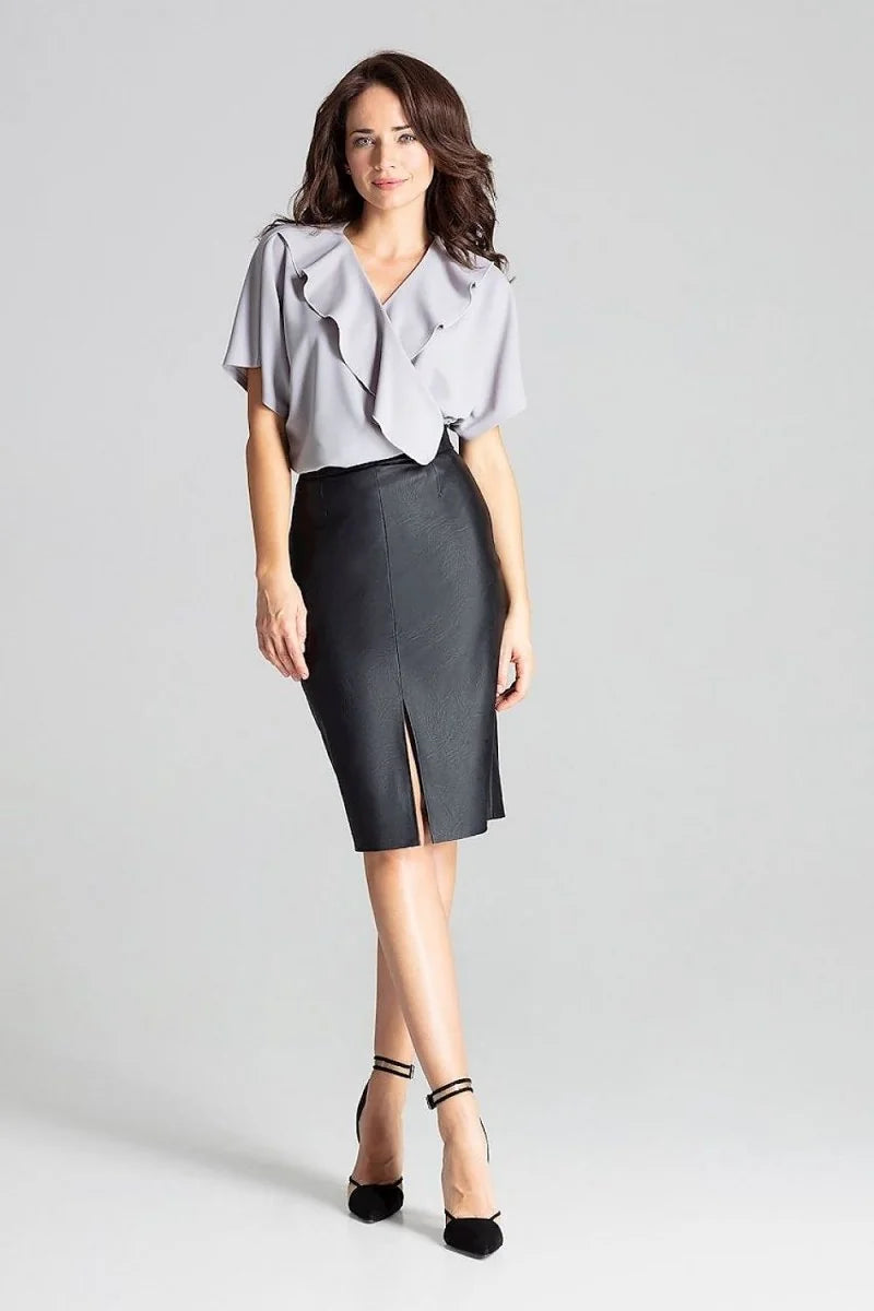 Black faux leather pencil skirt with a front slit, worn by a model on a grey background.