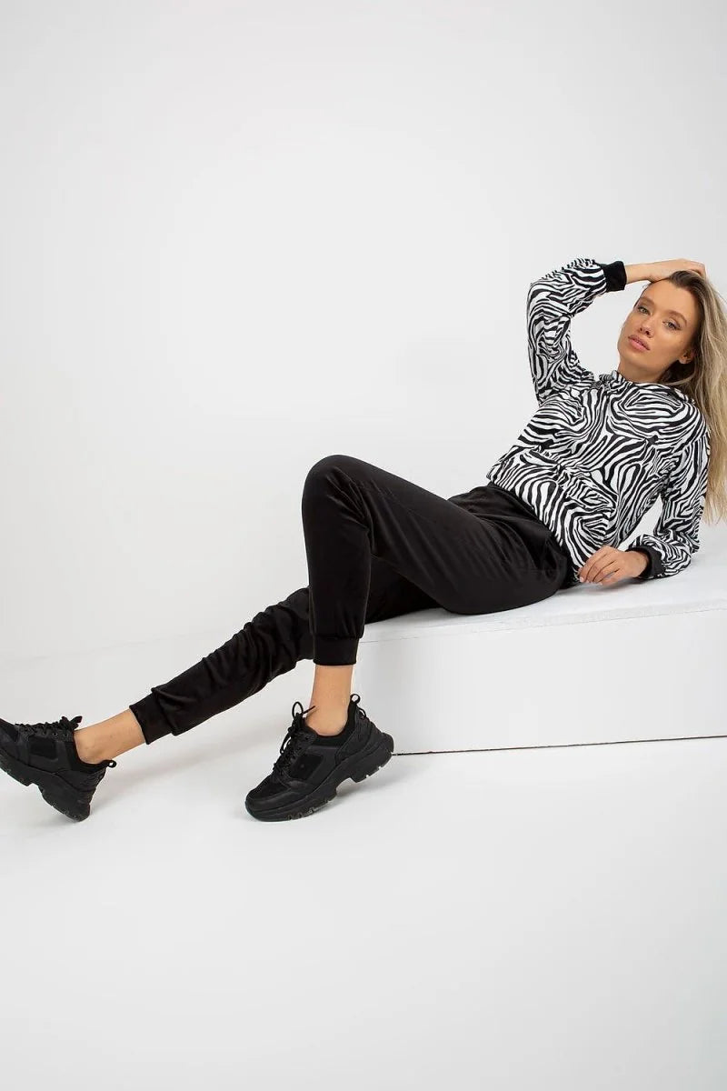 Black joggers with a zebra-print long-sleeve top on a model.