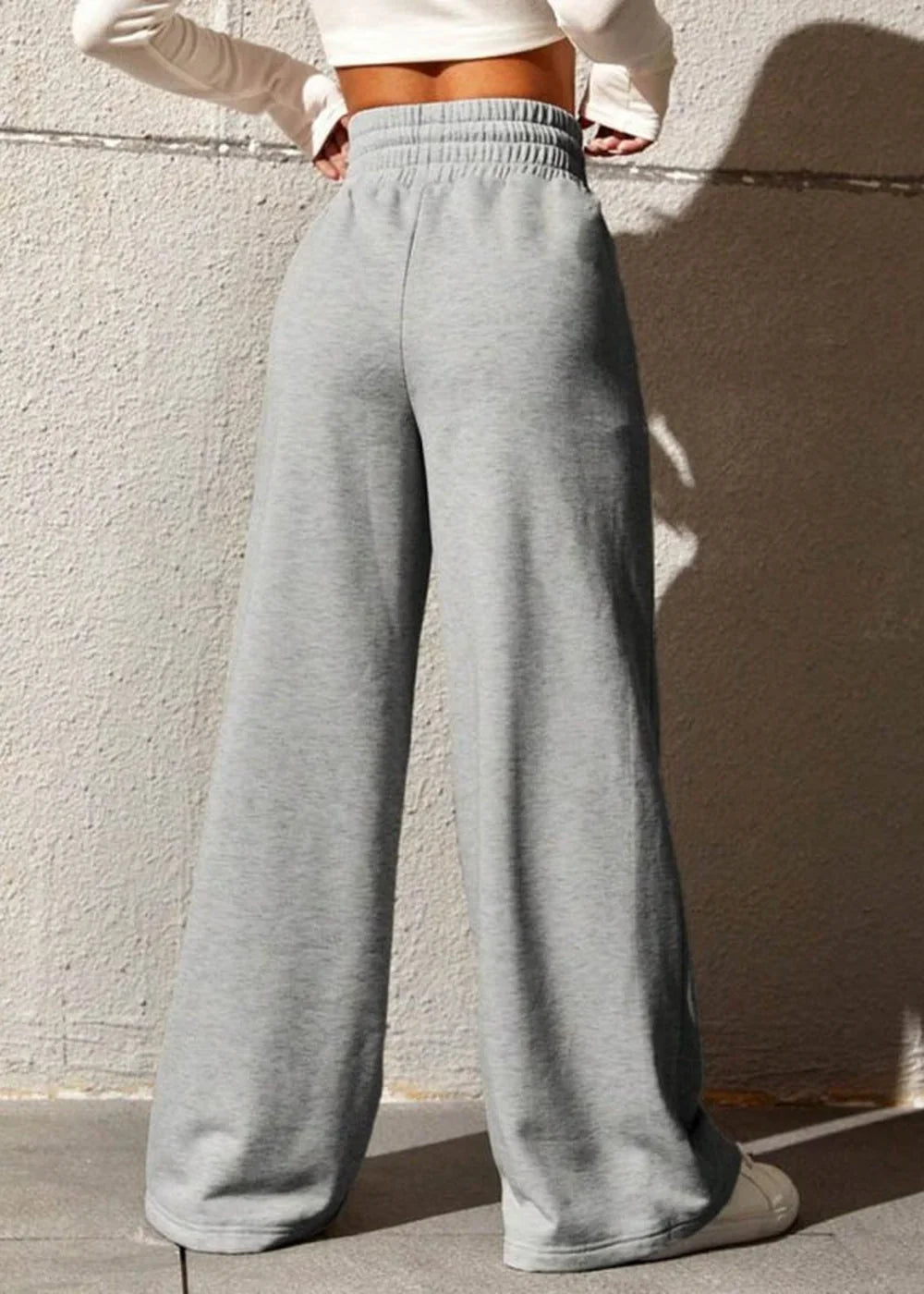 Grey wide-leg sweatpants with a cinched waist, shown on a model.