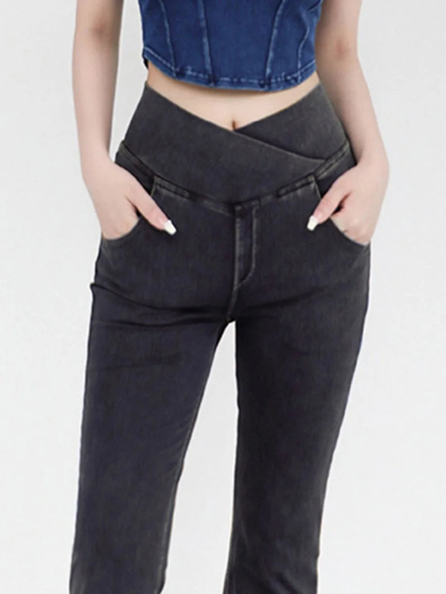 Close-up of dark grey jeans with a unique V-shaped waistline and front pockets.