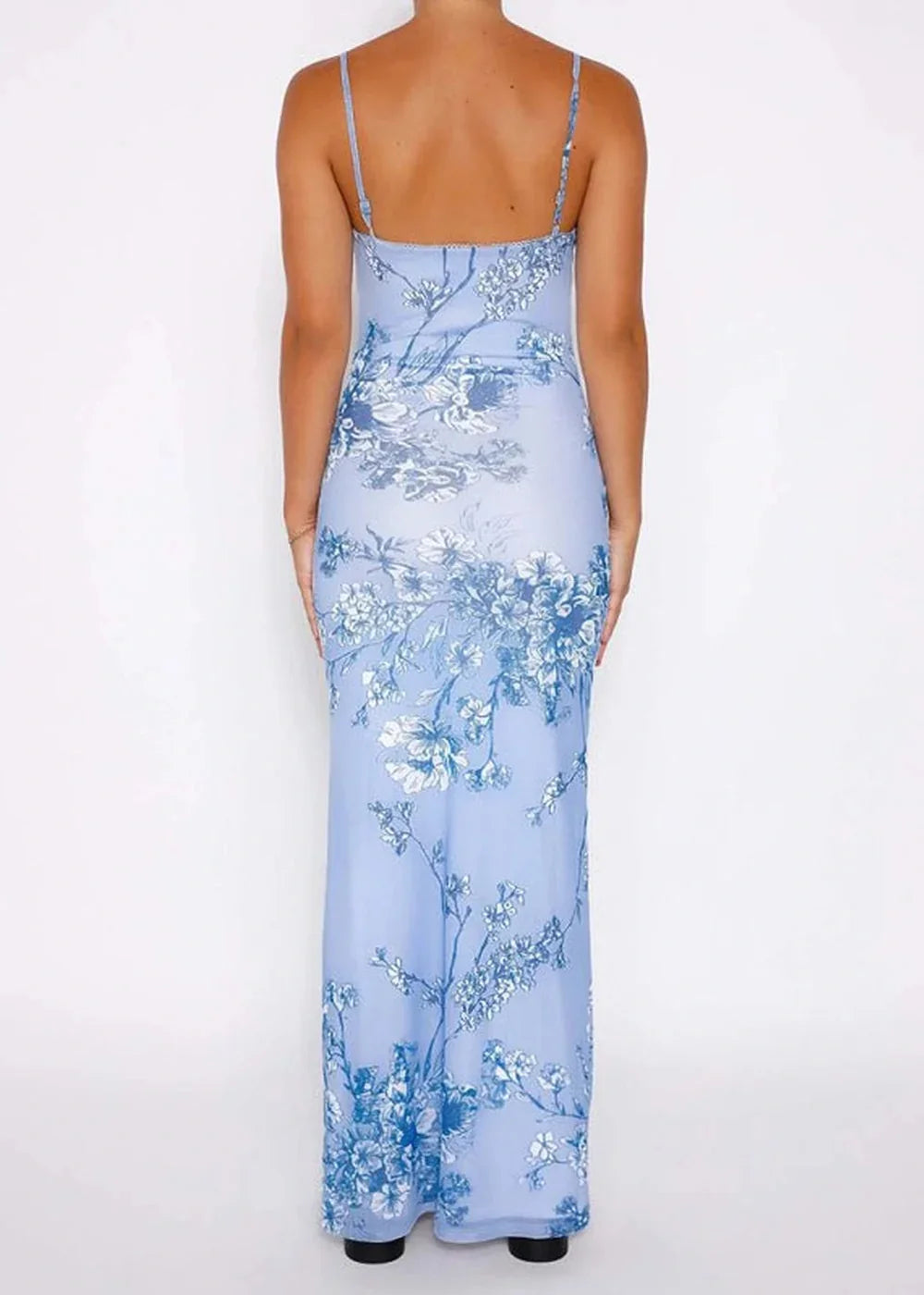 Clear blue maxi dress with a white and blue floral print, spaghetti straps, and a slim fit.