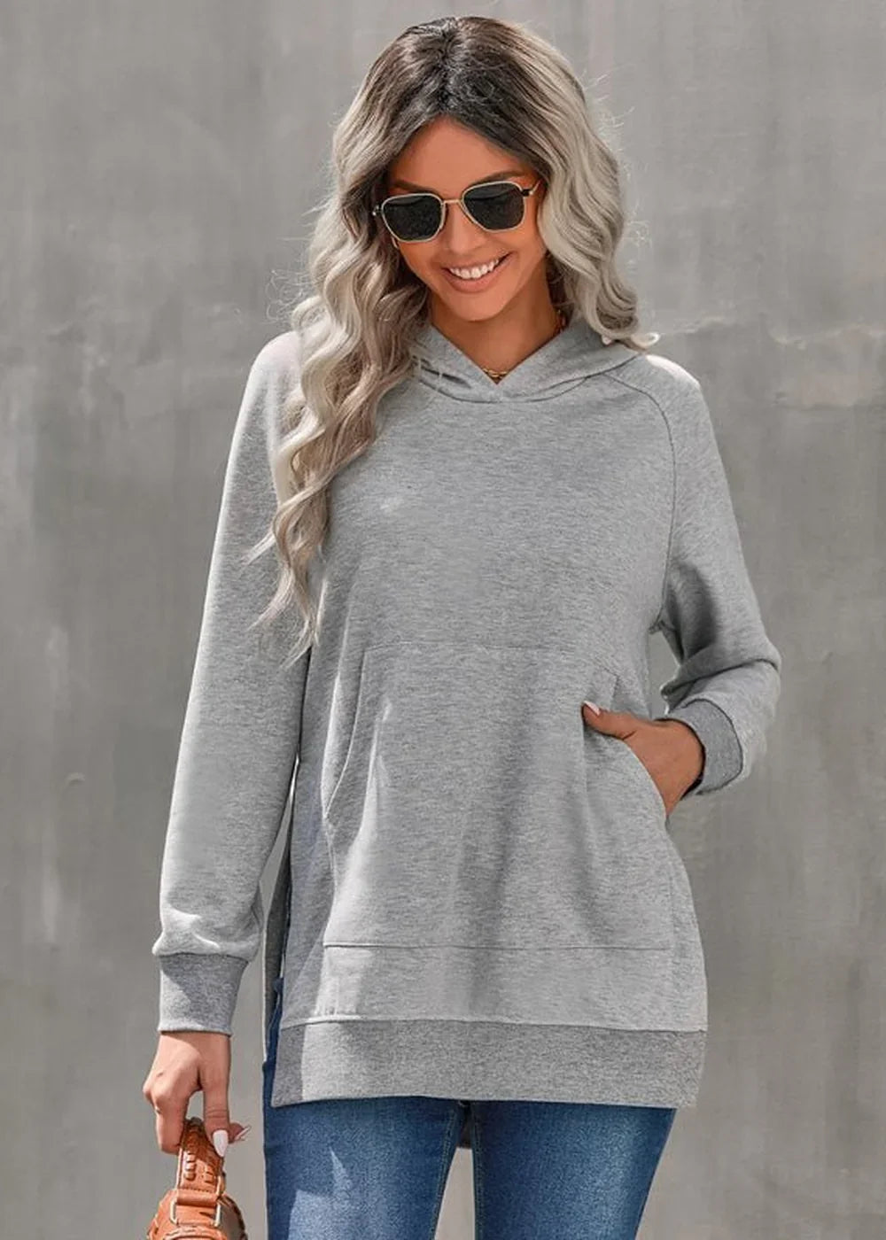 Light gray hooded sweatshirt with a kangaroo pocket and a relaxed fit, worn by a model.