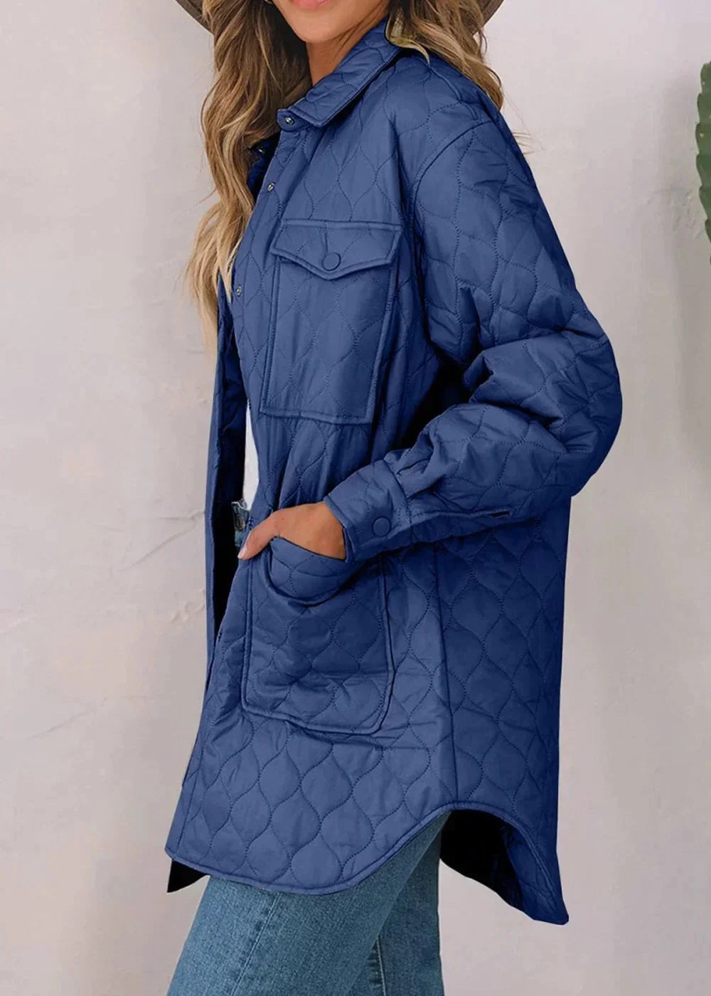 Quilted navy blue nylon jacket with diamond pattern and button-flap pockets, on model.