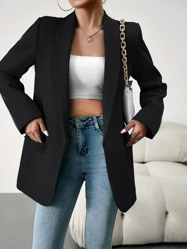 Black blazer with a white tube top and distressed denim jeans on a model.